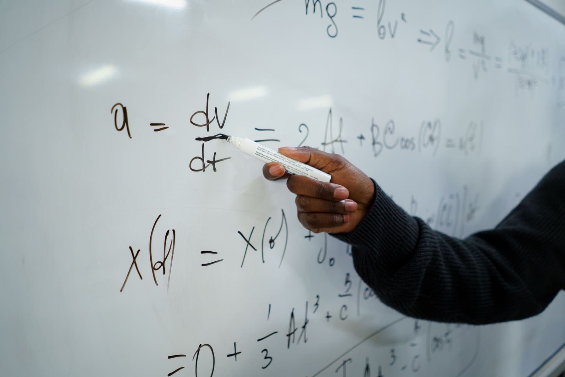 Maths equations being worked through on a whiteboard